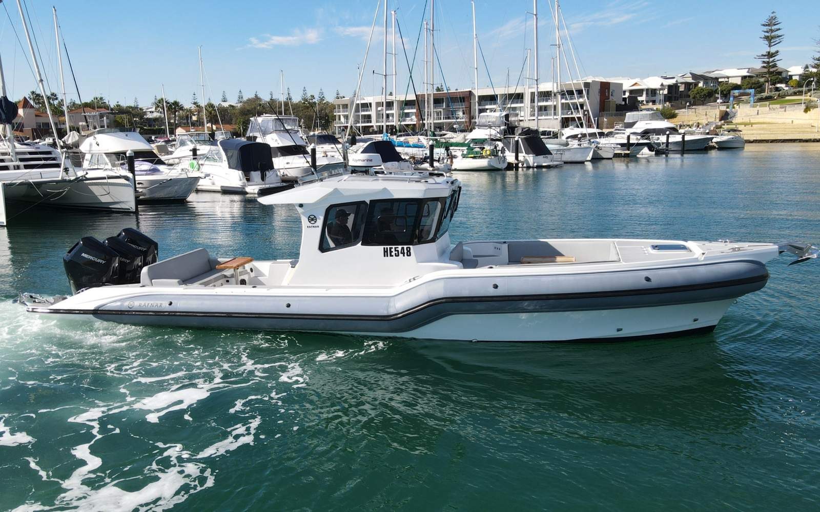 White Rafnar cabin vessel with three outboard engines in a marina